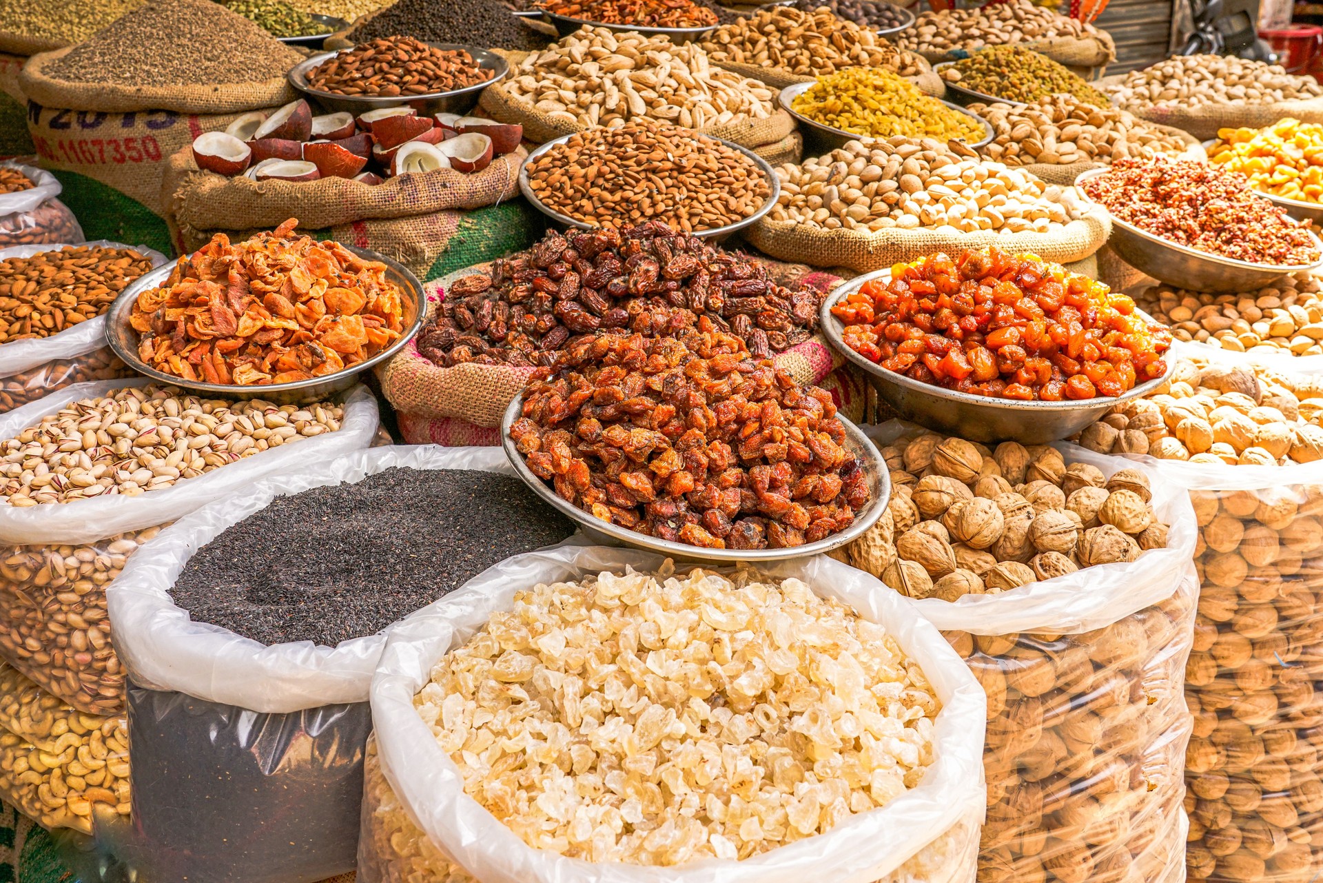This vibrant assortment of dried ingredients—almonds, dates, apricots, and spices—evokes traditional cooking, organic nutrition, and the sensory appeal of open-air markets